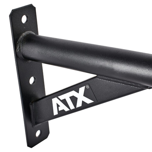 Close-up of a black metal ATX® Chin Up Bar Wall Mounted, showing a triangular support and white ATX letters. The bar is fixed to a flat vertical surface with bolt holes for mounting.