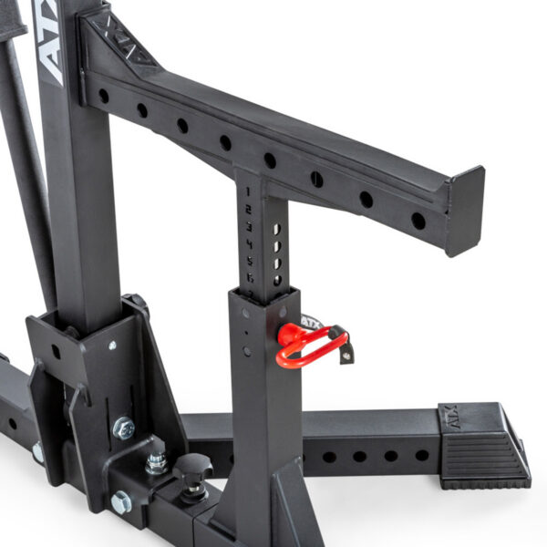 Close-up of the ATX® Competition Combo Rack, a sturdy black metal squat rack with a sleek design and red safety pin. It features multiple height adjustment holes and ATX labeling.