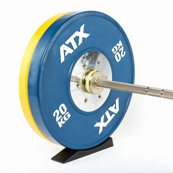 Close-up of a barbell with a blue 20 kg ATX weight plate mounted on a stand, ready for action. A yellow weight is partially visible behind the blue plate. Beneath, an ATX® Deadlift Wedge steadies the setup, ensuring optimal positioning as the barbell rests horizontally.