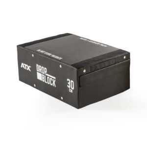 A black rectangular exercise block with white ATX Drop Block 30 cm text, sturdy side panels, and a handle, designed for gym use is known as the ATX® 30 cm Soft Drop Block.