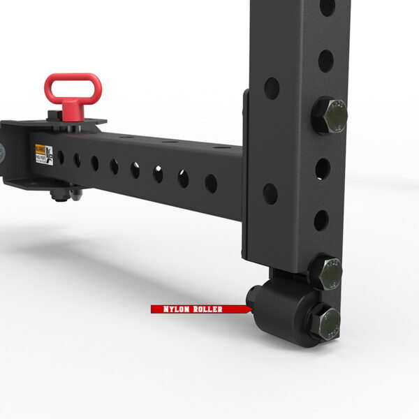 Close-up of a black metal bracket with a red nylon roller and multiple holes, part of a wall mount squat rack. A small lever with a red handle is attached to the bracket. The components are set against a plain white background.