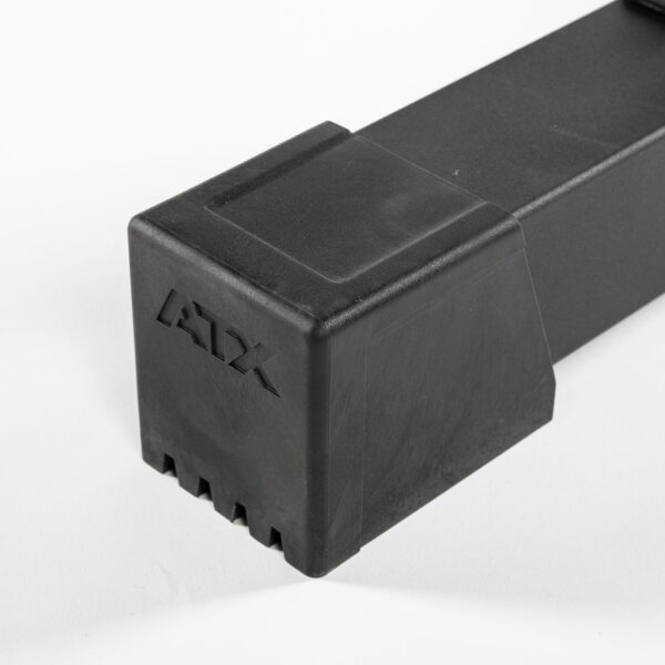 A black, rectangular ATX® Flat Bench PRO with grooves on one end and ATX embossed on the side is placed on a white surface.