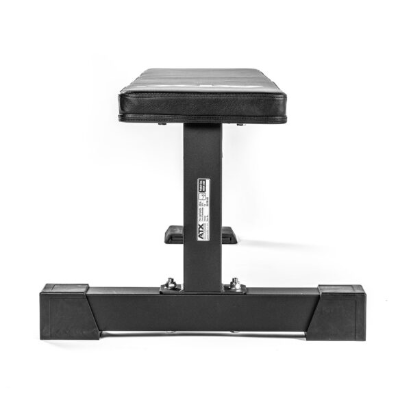 The ATX® Flat Bench PRO features a black padded surface on a sturdy metal frame with a wide base for stability. A visible label enhances it. Ideal for serious lifters, its perfect for any workout routine, all set against a plain white background.