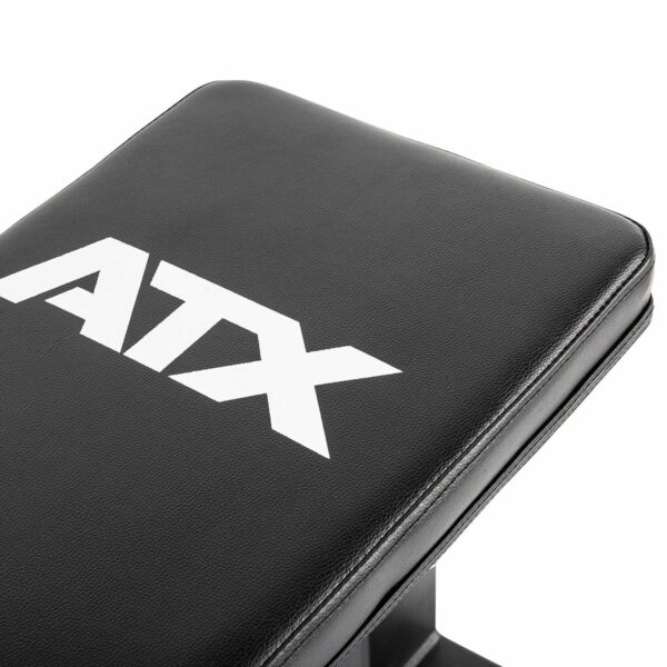 Close-up of the ATX® Flat Bench, a black flat weight lifting bench with ATX in white letters on the surface, highlighting its role as essential fitness equipment.