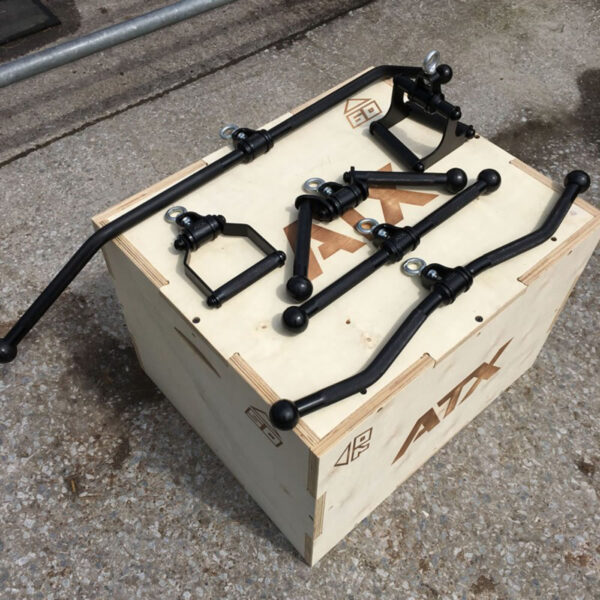 The ATX® EZ Curl Rotational Blackline, featuring sleek black metal stabilizer bars and mounting brackets, is showcased on a labeled wooden crate. Outdoors, the bars and connectors are carefully arranged on a concrete surface atop the crate.