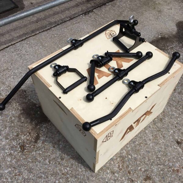The ATX® V Bar Rotational Blackline, a collection of black metal car parts including sway bars and connectors, is displayed on a wooden crate labeled ATX on a concrete surface.