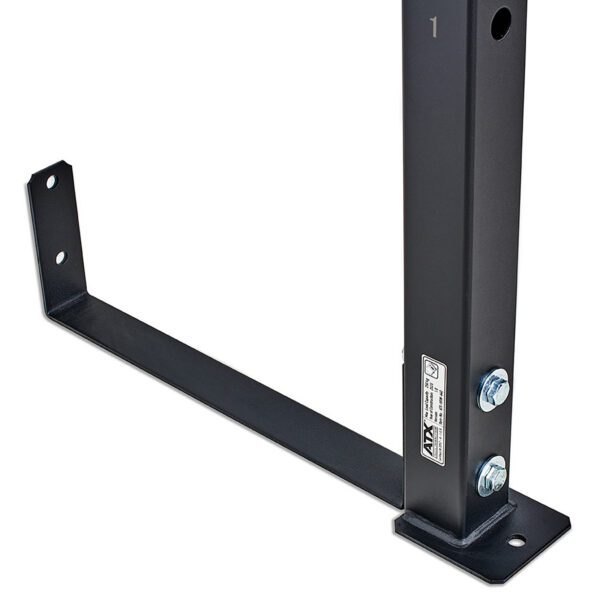 The ATX® Wall Mounted Squat Rack includes a black metal L-shaped support bracket featuring a vertical section with two bolts. Its flat base has mounting holes and is labeled with small text and icons for functionality and clarity.