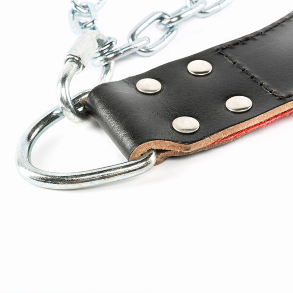 The ATX® Leather Dip Belt features a black leather strap with metal rivets and a sturdy chain ending in a D-ring. A lining of red material accents the design against a white background, highlighting its bold look.