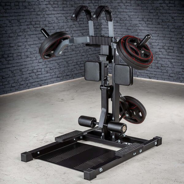 The ATX® Leg Master stands against a brick wall on a concrete floor and features padded supports and a footplate for lower body workouts. This versatile squat machine doubles as a leg master, making it perfect for enhancing standing leg curls in your routine.