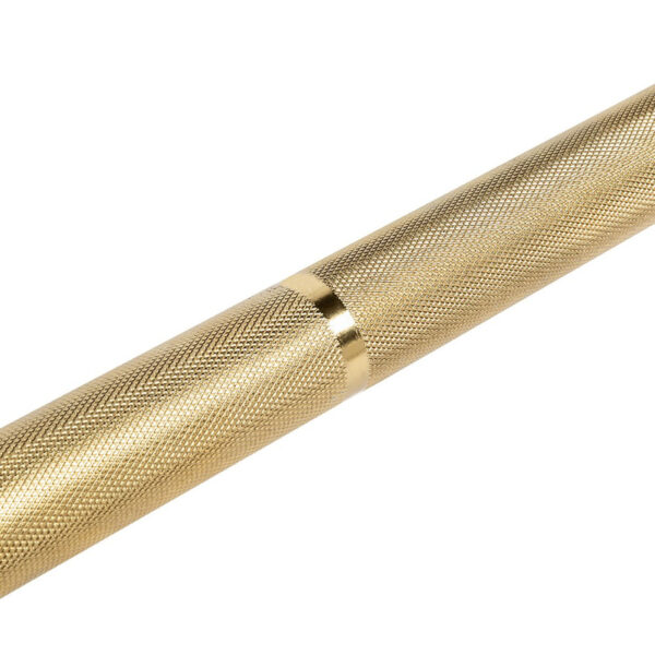 Close-up of the ATX® Olympic Golden Powerlifting Bar, featuring a gold-colored, textured metal design with a smooth, shiny band in the center. Its intricately patterned surface enhances grip, resembling weightlifting equipment against a plain white background.