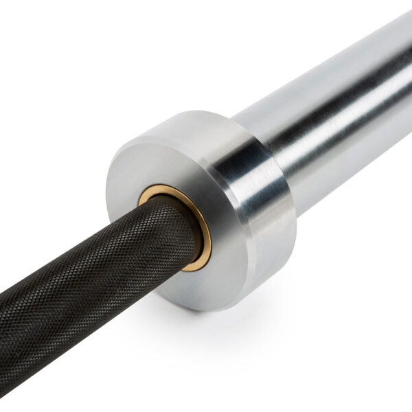 Close-up of the ATX® Olympic Power Barbell - Black featuring a smooth silver sleeve and black textured grip on the bar. A golden ring marks where the bar connects, enhancing its design.