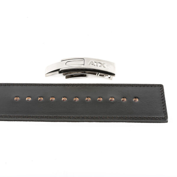 A black leather strap with evenly spaced holes is laid out horizontally, above which sits a modern silver metal clasp labeled ATX®. The clasp is detached from the strap.