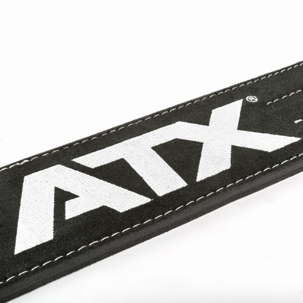 Close-up of the ATX® Lever Suede Power Belt in black suede with white stitching, prominently displaying the bold white letters "ATX" on it against a plain, light-colored background.