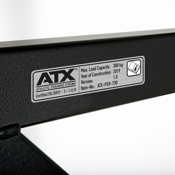 Close-up of the label on the ATX® Gladiator Chin Up Bar detailing: Max Load Capacity - 300 kg, Year of Construction - 2019, Version - 1.0, Item No. - ATX-PUX-730, Certified EN 20957. Branding reads ATX Athletic Training Xtreme.