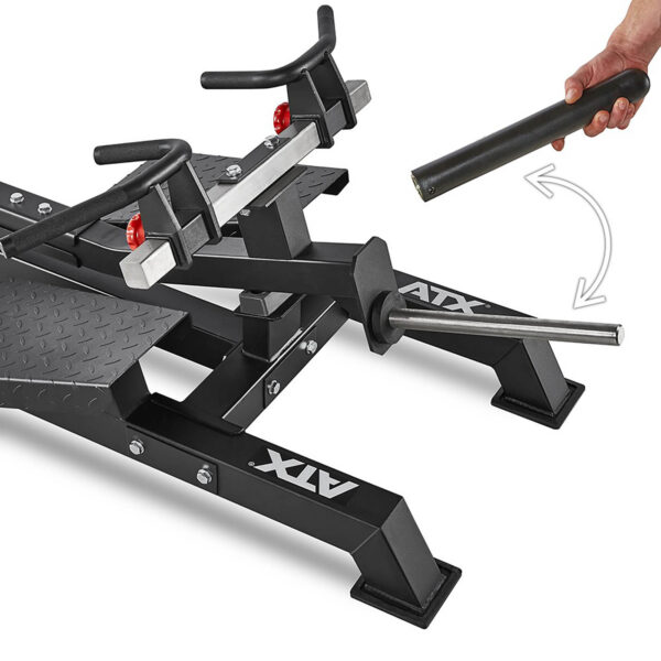A black ATX Plate Loaded T-Bar Row machine with adjustable handles and a removable component is showcased. A hand grips a cylindrical part, illustrating how it connects to the main structure. The base features sturdy, angled legs for enhanced stability.