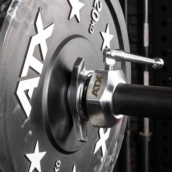 A close-up features a 20 kg weight plate secured by ATX® Competition Powerlifting Collars IPF, with star designs on the plate against a sleek black rack backdrop.