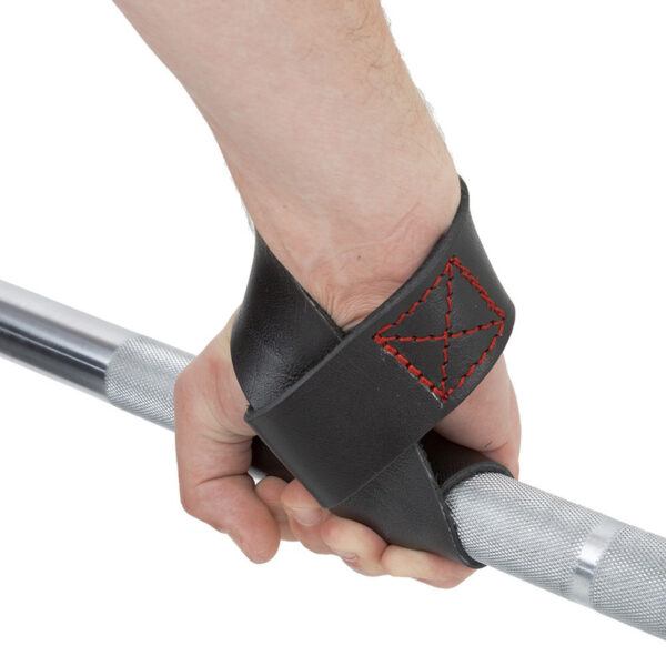 A hand grips a silver barbell, encased in a black leather lifting strap with red stitching, reminiscent of the ATX® Bulls Strongman Yoke.