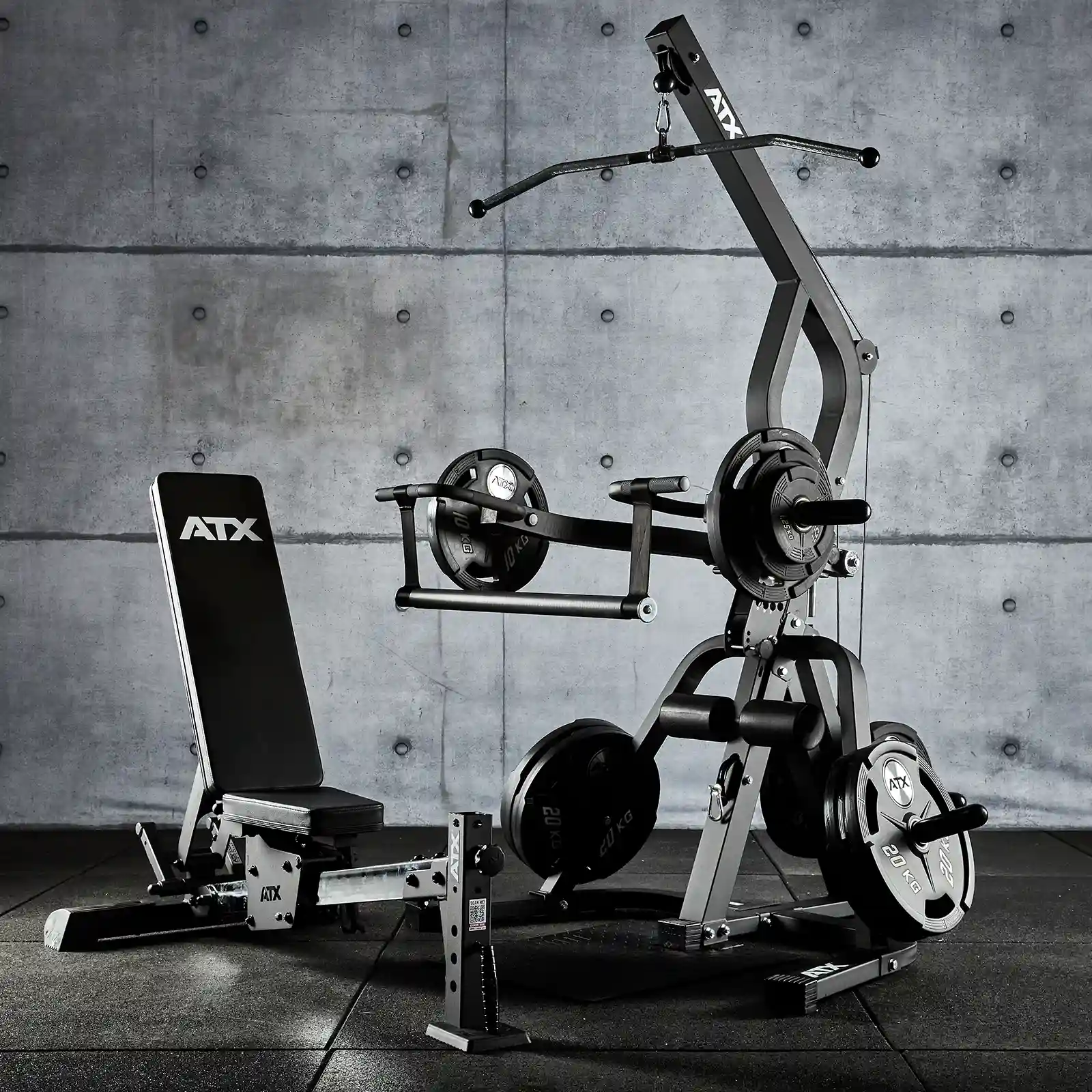 A multi-function ATX Triplex Multi gym with weights and an adjustable bench stands against a concrete wall. The compact home gym features a pulley system and weight plates for diverse exercises, all professionally labeled ATX. The floor is comfortably covered with gym mats.