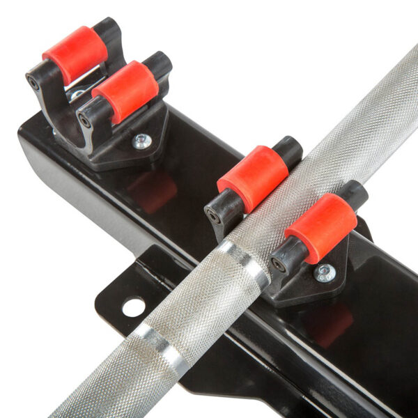Close-up of the Barbell Cue Rack - Wall Mounted, featuring a textured metal bar secured by red and black rollers on a sturdy black mount attached to a flat surface with visible screws.