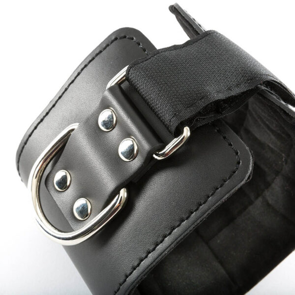 Close-up of the Cable Machine Ankle Cuff in black PU leather, featuring a silver metal buckle and rivets. A black strap threads through the buckle, with visible stitching adding texture and detail.