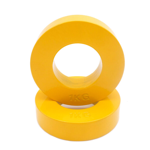 Two 1KG weights from the Power Maxx Olympic 5kg Fractional Plate Set are stacked; one is upright with the hole facing forward, and the other lies flat beneath it. Both have smooth surfaces and bright yellow coloring.