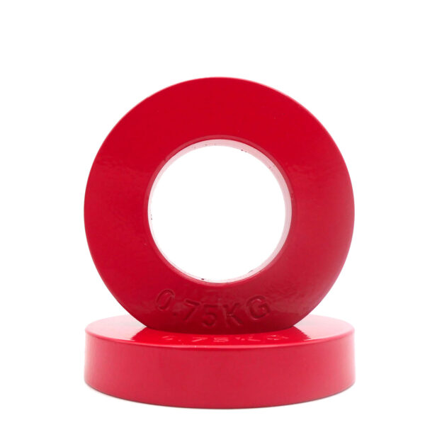 Two red plates from the Power Maxx Olympic 5kg Fractional Plate Set are displayed artistically: one is upright with its circular opening visible, while the other lies flat beneath. Their glossy surfaces beautifully reflect light.