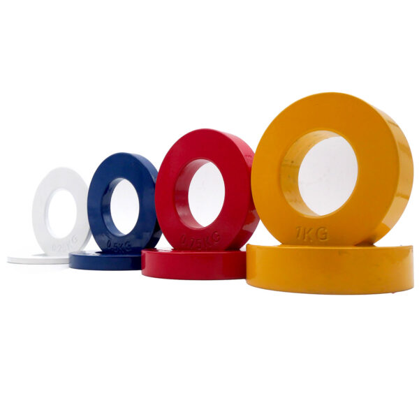 A row of five Power Maxx Olympic 5kg Fractional Plates displays a vibrant palette of white, blue, red, and yellow. Arranged smallest to largest on a white surface, each is marked with its weight.