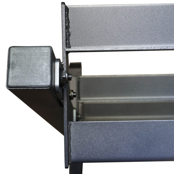 The Power Maxx Compact Hex Dumbbell Rack features a metallic rectangular bracket with a textured finish, bolts, and angular edges. An open section reveals its steel-gray surface with a light sheen, indicating sturdy construction.