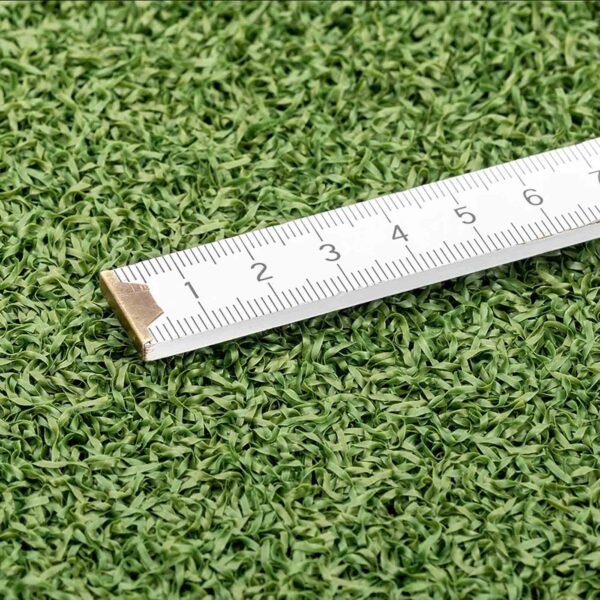 A GymFloor® RTS Turf 50x50@20mm patch has a tape measure in centimeters on it, with the green turf contrasting against the white tape for clear visibility of its markings.