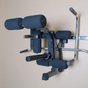 The Ironmaster Ultimate Chin Up Attachment for IM2000 is a versatile wall-mounted gym tool featuring padded supports and metal handles, perfect for strength training exercises like pull-ups, dips, and leg raises against a beige wall background.