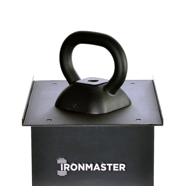 An Ironmaster Adjustable Kettlebell Handle sits on a textured metal platform, with IRONMASTER printed on the front.