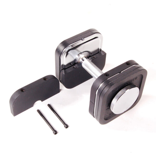 An Ironmaster Heavy Handle Kit adjustable dumbbell, sleek in black and silver with a central dial, rests on a white surface. Nearby are two black connector pieces and rods for adjusting or assembling the dumbbell.