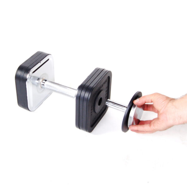 A hand holds a plate near an Ironmaster Heavy Handle Kit with square weight plates on a pristine white background.