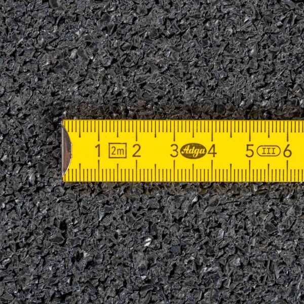 A yellow measuring tape with black markings, displaying numbers from 1 to 6, lies on a textured black surface like the Gymfloor® 20mm 1m x 1m.