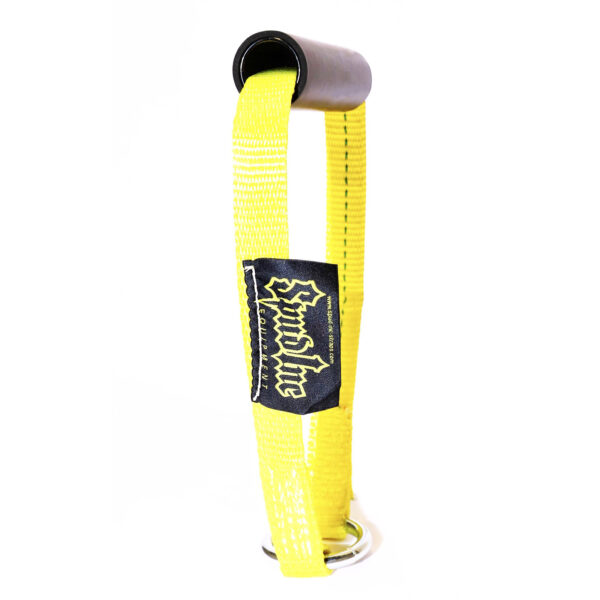 The Spud KettleStrap Kettlebell Strap is yellow with a black cylindrical handle on top, metal D-rings at the bottom, and a black patch featuring stylized gothic font.