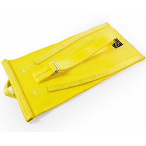 The Spud Inc Mini Me Sled, a yellow canvas bag with a metal buckle and two straps, lies flat on a white surface. A small black label is attached to its top corner.