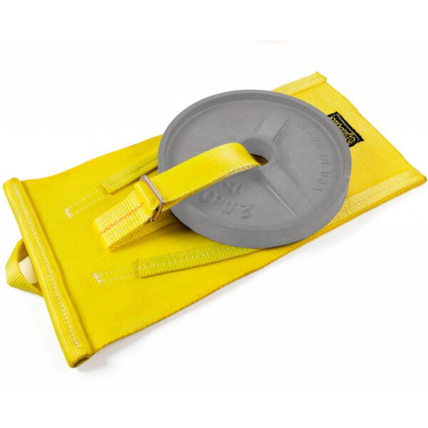 A gray weight plate sits on the Spud Inc Mini Me Sled, a yellow nylon gym sled with reinforced stitching and strap, featuring a handle for fitness training and resistance exercises.