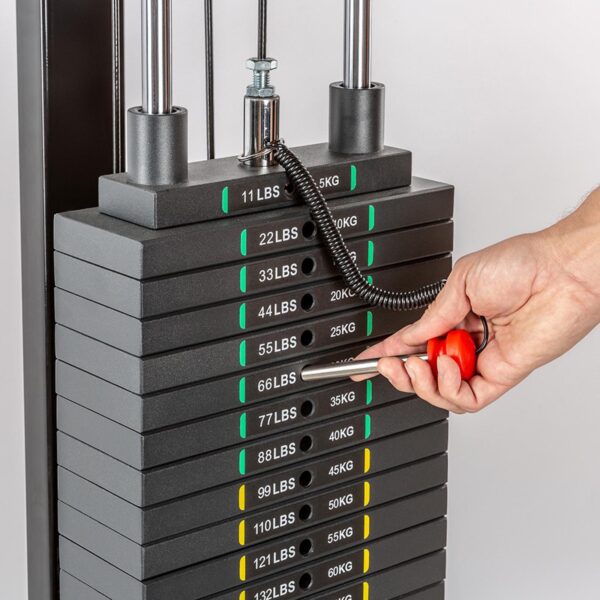 A hand uses the Magnetic 10mm Weight Stack Pin 140mm to adjust a stacked weight machine with markings from 11 lbs (5 kg) to 132 lbs (60 kg). The pin is set at 55 lbs (25 kg), and the weights are labeled in both pounds and kilograms.