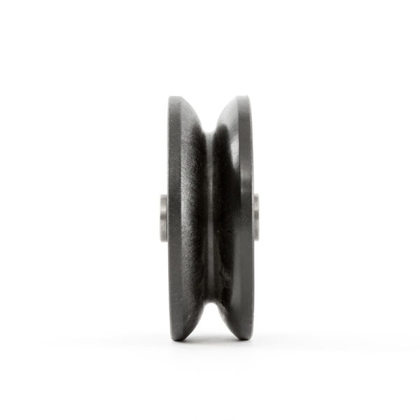 Side view of the ATX® Pull-Up Add-On for Rigs and Racks, showcasing a black metal pulley wheel with a central groove against a white background. The metallic texture and intricate details are clearly visible.