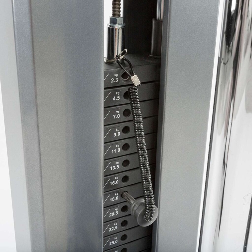 Close-up of a weight stack on a single cable machine, showing weights labeled in kilograms ranging from 2.3 to 25. The selector pin is inserted at 9 kg, and the stack has a coiled attachment. The gym equipment boasts a sleek metallic finish.