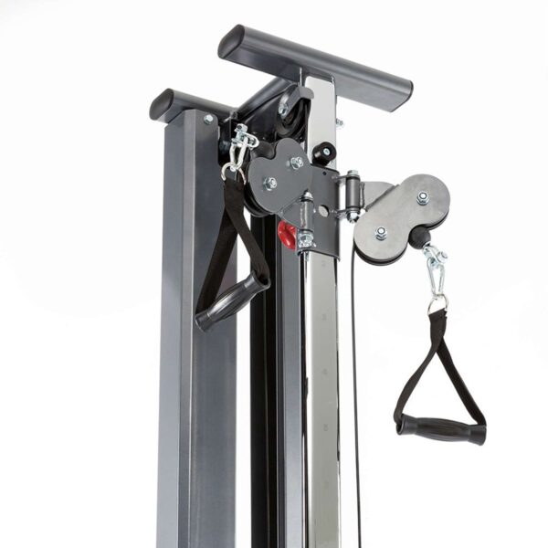 A close-up of a cable trainer on a home gym machine showcases black straps, metal chains, and adjustable handles. This setup, akin to the wall-mounted cable machine design, is perfect for various strength training exercises.