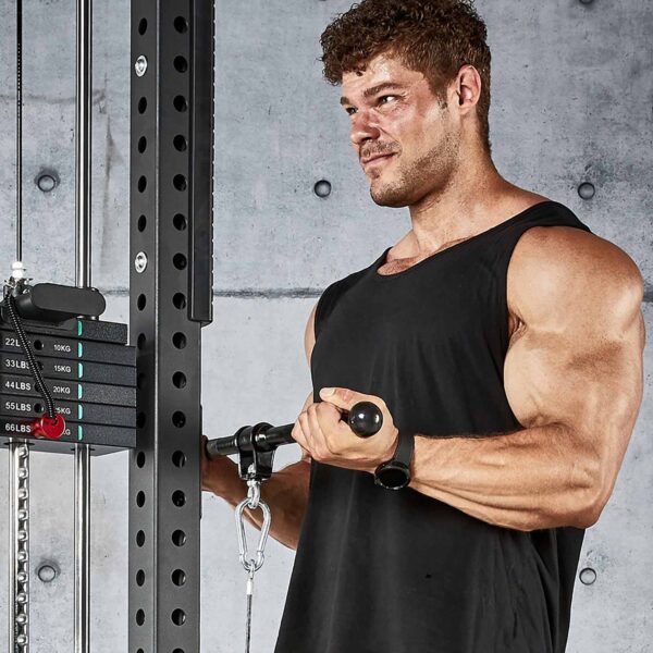 A muscular man in a black tank top does cable curls with an ATX® Straight Bar Rotational Blackline, focused against a concrete wall with a weight stack visible beside him.