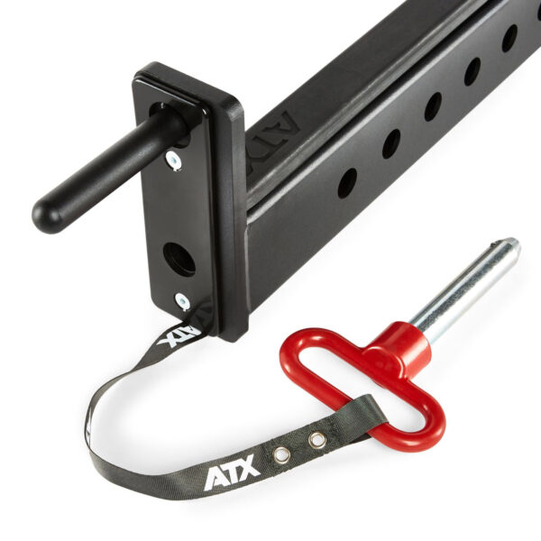 Close-up of black ATX® Spotter Bars 75cm fitness equipment attachment, featuring a rectangular frame with multiple holes, a handle, and a red safety pin with a strap, all marked with the brand ATX.