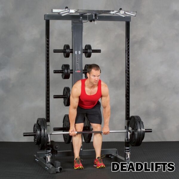 A person in a red tank top and black shorts performs a deadlift with the Ironmaster IM2000 Self-Spotting Smith Machine on a weightlifting rack. The word DEADLIFTS is written in bold at the bottom right.