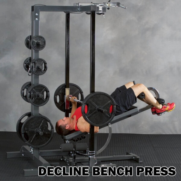 A person in gym attire uses the Ironmaster IM2000 Self-Spotting Smith Machine for a decline bench press, with the bench angled downward and weight plates stacked on both sides.