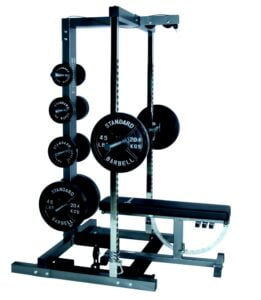 A weightlifting rack with various weight plates and a barbell. The setup includes a bench positioned beneath the bar. The weight plates are labeled Standard Barbell with weights in pounds and kilograms.