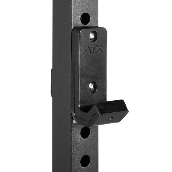 Close-up of a black metal J-hook attached to an ATX® Half Rack with holes for adjustable height. The brand name ATX is visible, showcasing its robust design for weightlifting support.