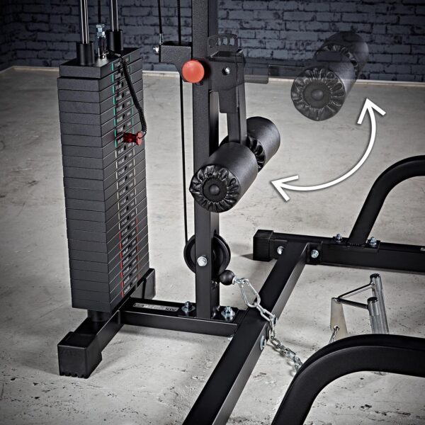 The ATX® Smith Machine System Stack Weight 115 kg is shown with a padded leg attachment in front of a gray brick wall on a concrete floor. An arrow highlights the adjustable motion of the leg attachment.