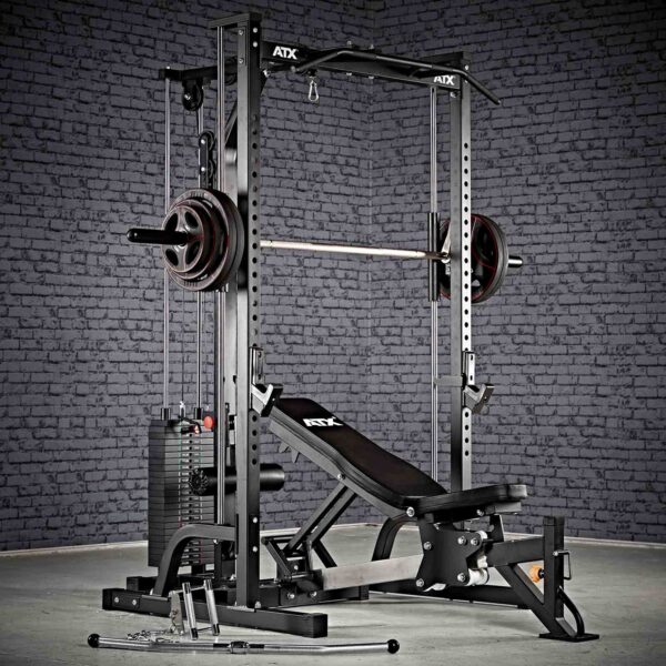 Against a brick wall, the ATX® Smith Machine System Stack Weight 115 kg offers multi-functional home gym equipment, featuring a bench press, adjustable weight rack, and attachments like cables and bars for diverse workout routines.