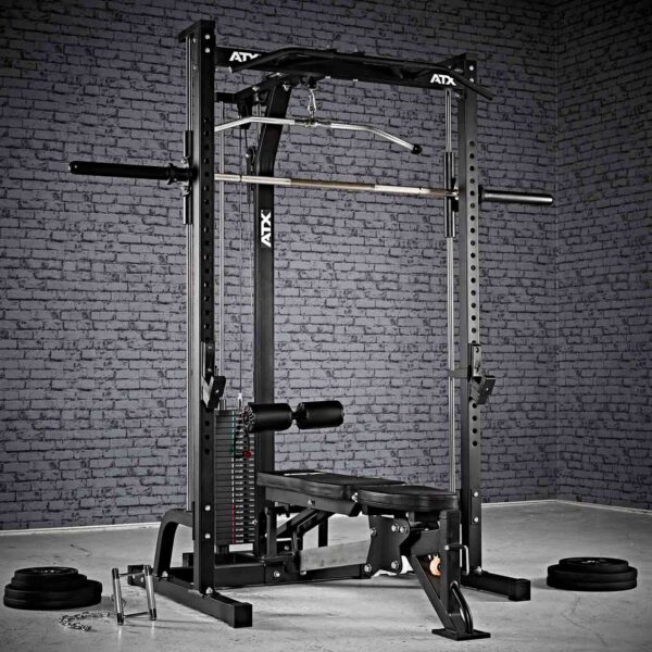 A home gym setup includes the ATX® Smith Machine System Stack Weight 115 kg, featuring a bench, barbell, and adjustable weights. The textured gray brick wall serves as the background, with weight plates scattered on the floor.